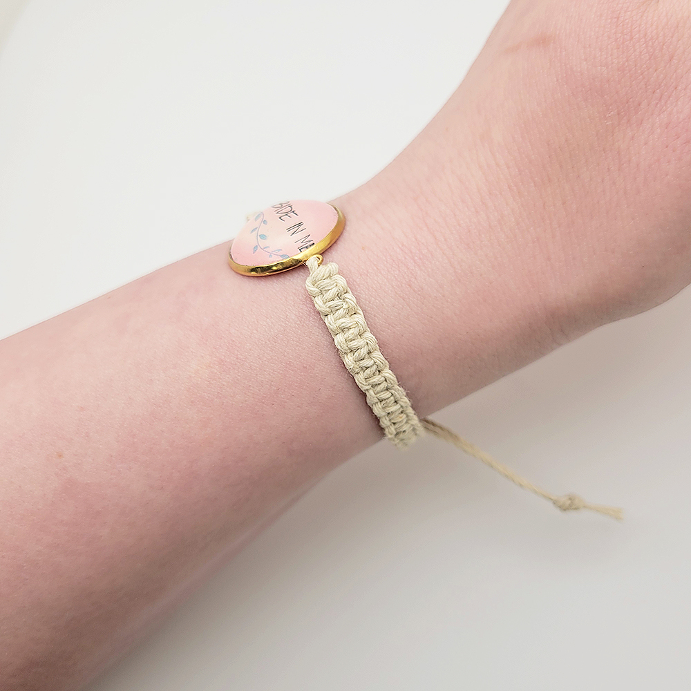 Abide in Me hemp bracelet worn on wrist with pink glass cabochon charm and natural cord, Christian faith bracelet.