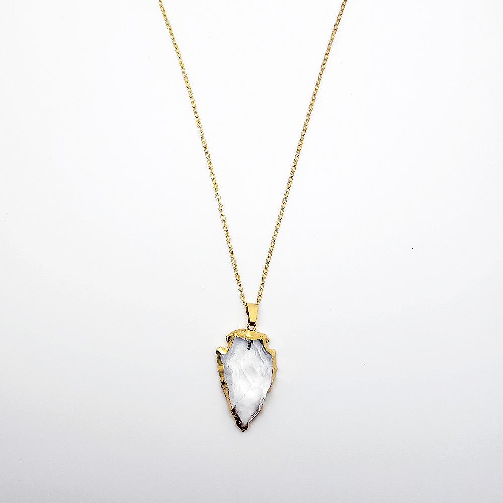Gold arrowhead clear quartz pendant necklace on delicate gold chain against white background
