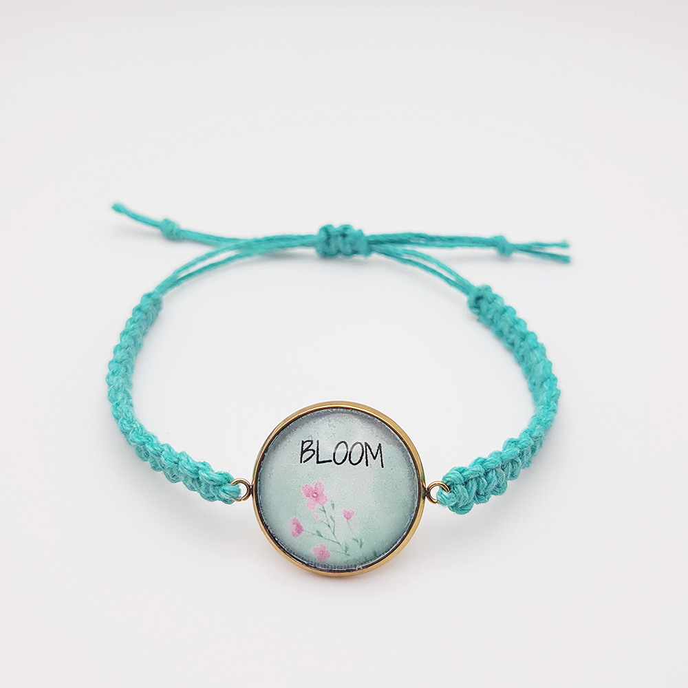 Bloom hemp bracelet with floral charm on turquoise cord, handmade adjustable faith bracelet on white background
