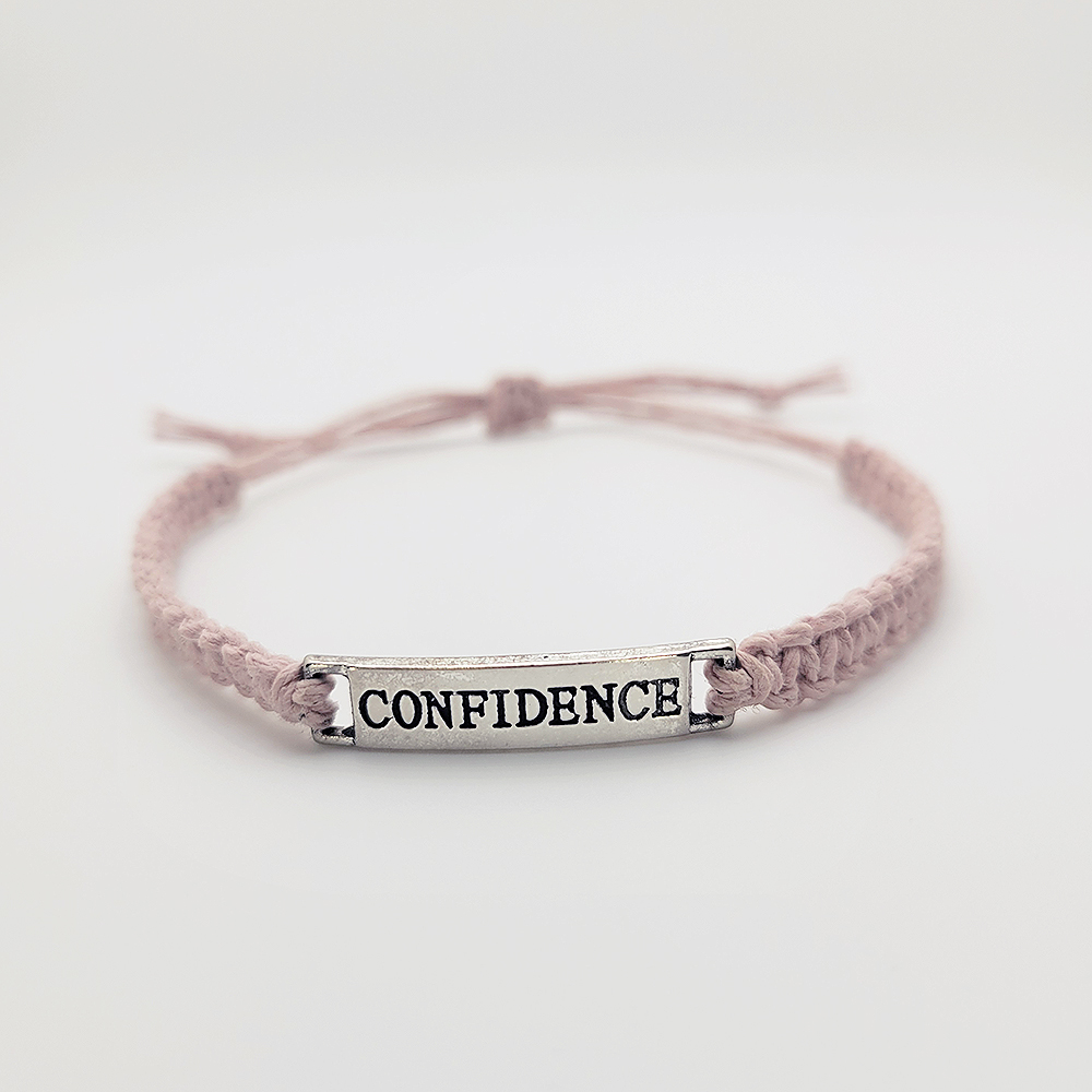 Minimalist handmade cord bracelet with silver Confidence charm, adjustable sliding knot bracelet on blush pink cord.