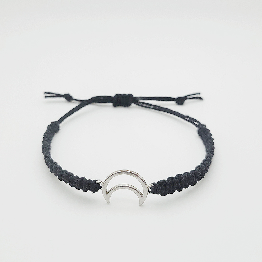 Handmade moon charm hemp bracelet with adjustable black cord and silver crescent charm on white background
