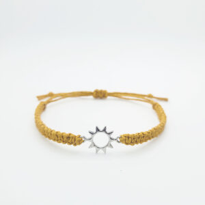 Handmade sun charm hemp bracelet with adjustable mustard cord and silver sun charm on white background