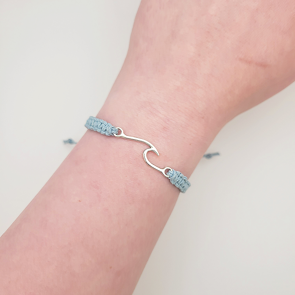 Blue hemp wave bracelet with silver charm worn on wrist, adjustable handmade bracelet inspired by Isaiah 43:2