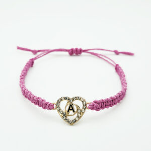 Handmade pink hemp bracelet with a gold rhinestone heart charm featuring the letter A on a white background